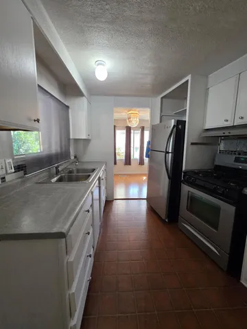 a kitchen with stainless steel appliances granite countertop a sink stove and refrigerator