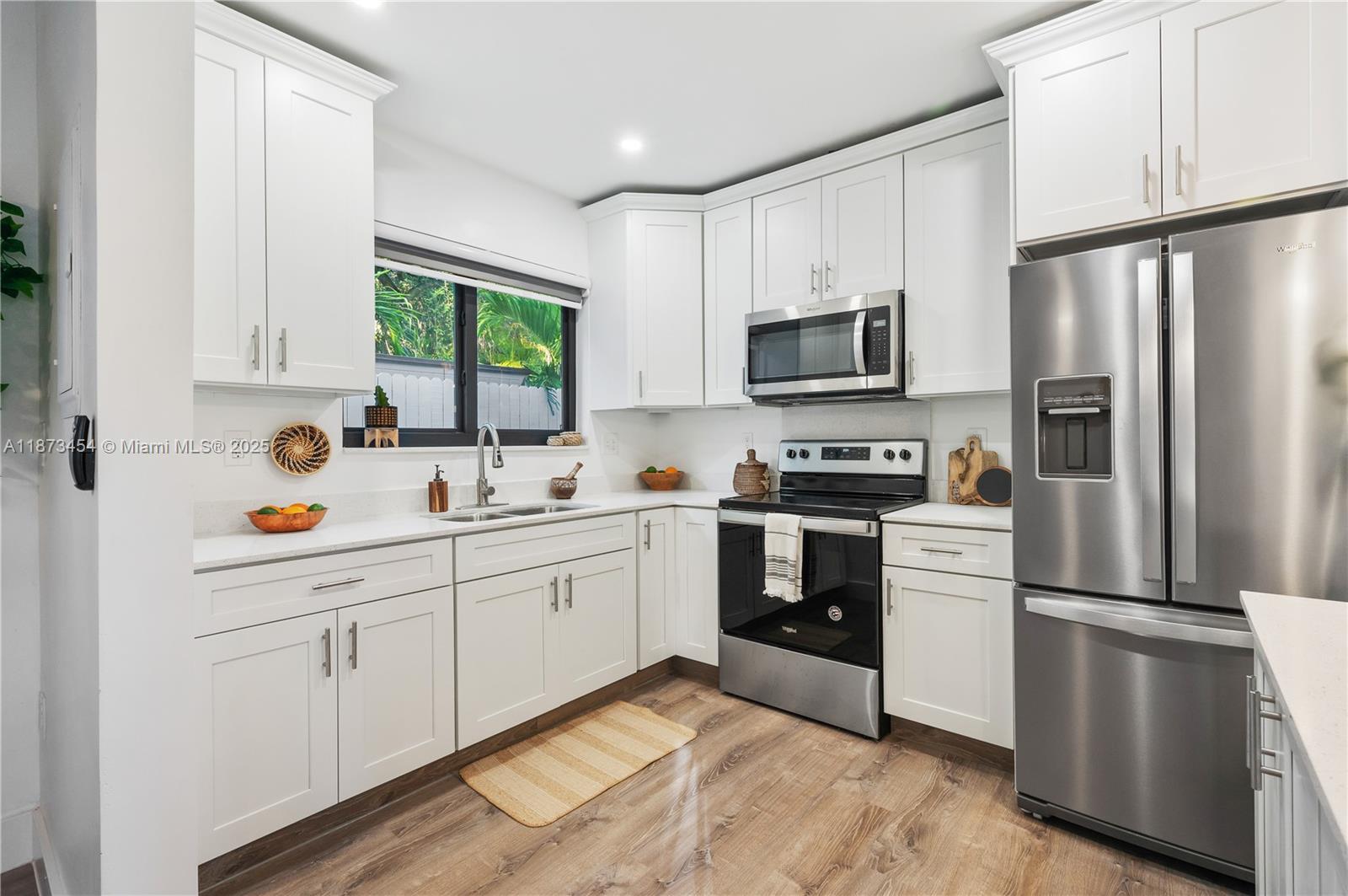 2917 Center Street Miami, FL 33133 - Photo 12 of 32 a kitchen with granite countertop white cabinets and stainless steel appliances