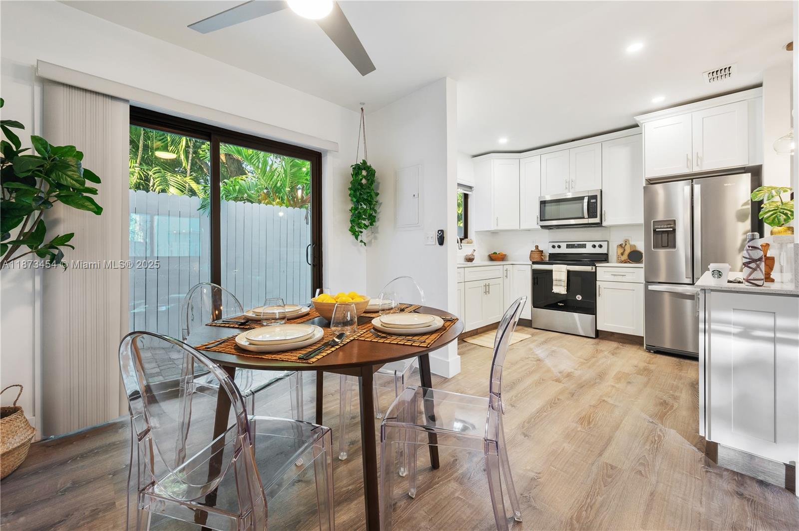 2917 Center Street Miami, FL 33133 - Photo 10 of 32 a kitchen with stainless steel appliances granite countertop a stove a refrigerator a kitchen island a table and chairs in it