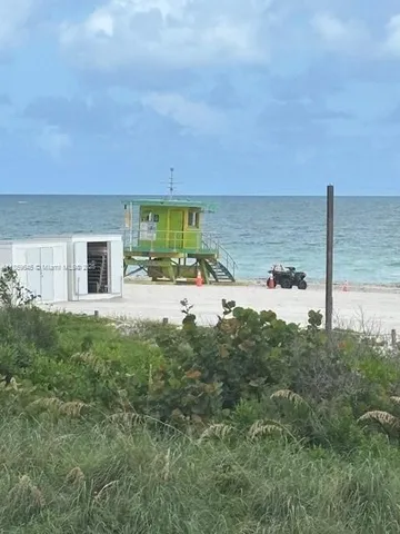 a view of a house with a yard and lake view
