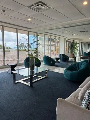 a living room with furniture gym equipment and a large window