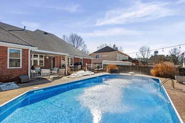 a view of a house with swimming pool and sitting area