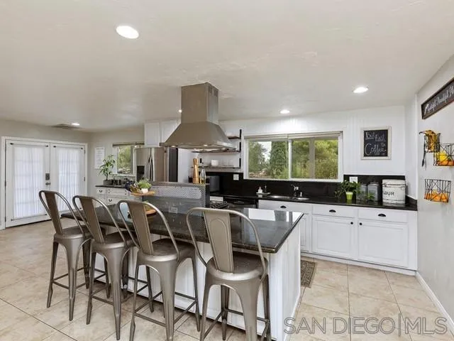 6460 Rainbow Heights Road Fallbrook, CA 92028 - Photo 12 of 38 a kitchen with stainless steel appliances a table chairs refrigerator and sink