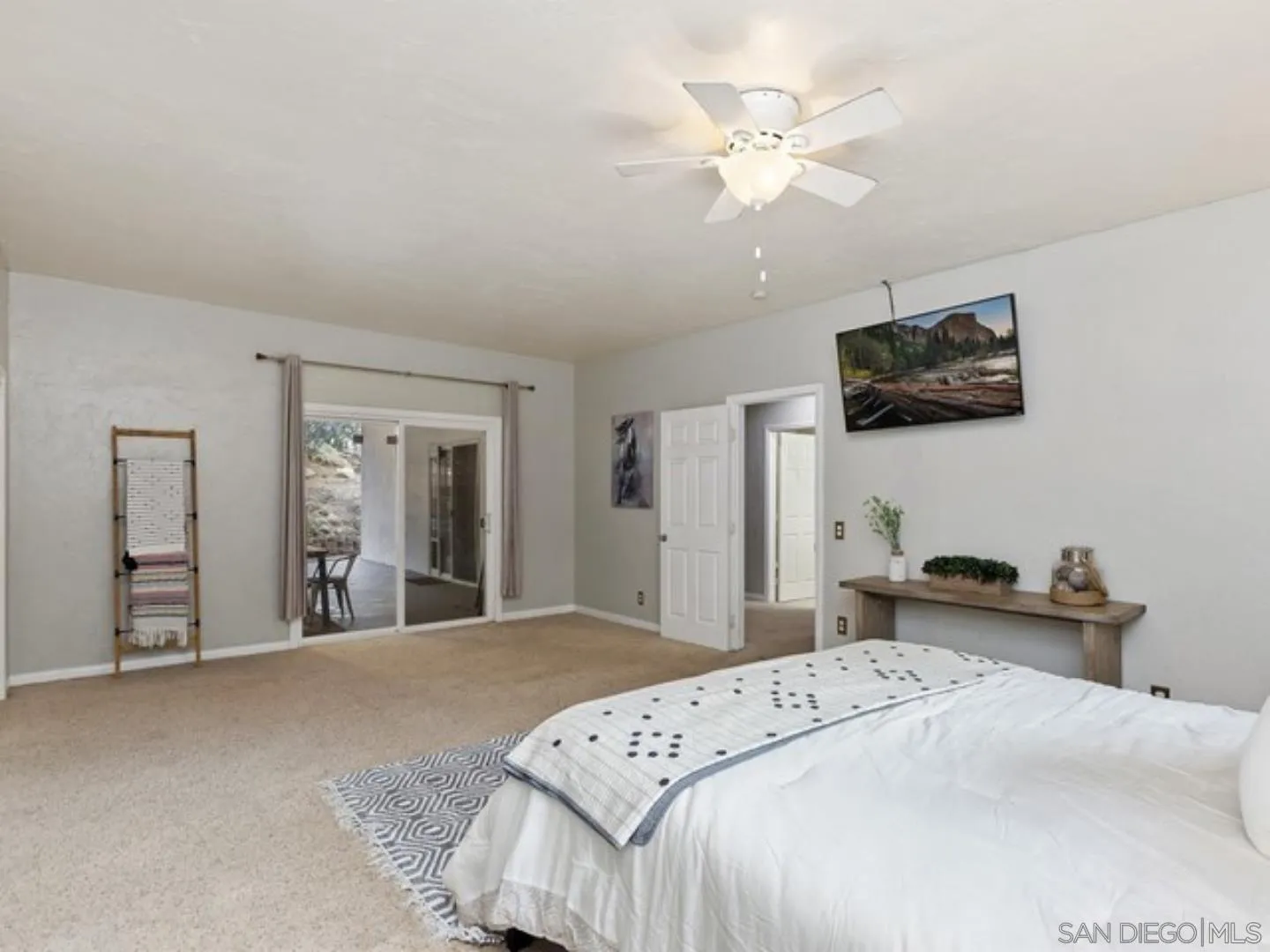 6460 Rainbow Heights Road Fallbrook, CA 92028 - Photo 25 of 38 a bedroom with a bed a flat screen tv and a chandelier