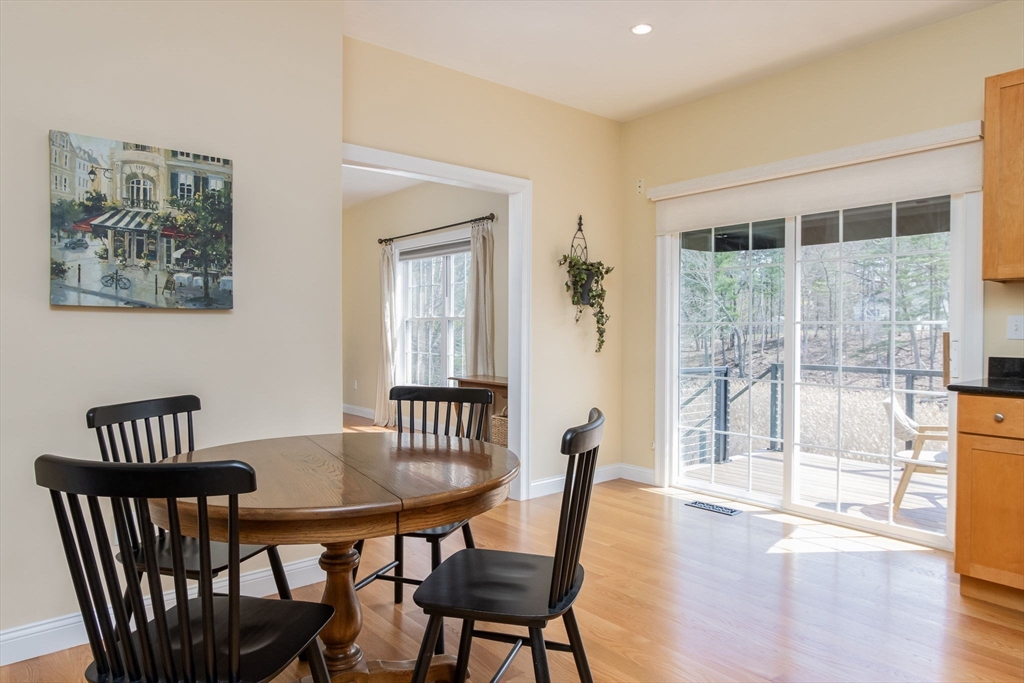 256 Lowell Road Groton, MA 01450 - Photo 12 of 40 a view of a dining room with furniture a chandelier and wooden floor