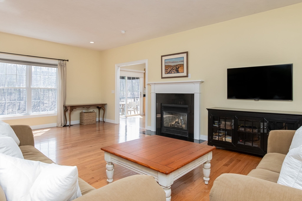 256 Lowell Road Groton, MA 01450 - Photo 17 of 40 a living room with furniture a flat screen tv and a fireplace