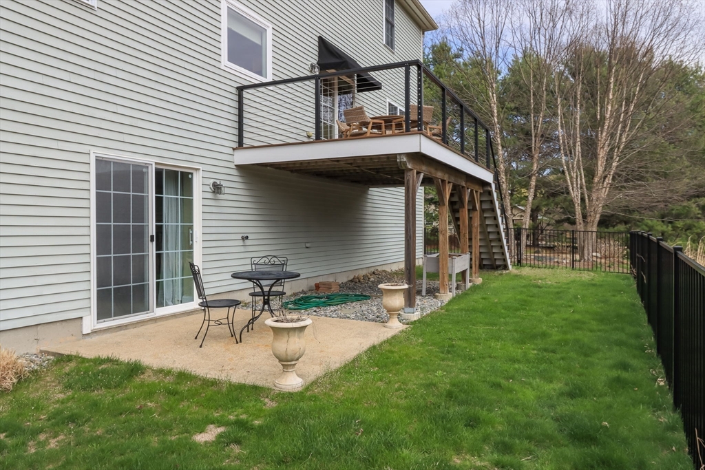 256 Lowell Road Groton, MA 01450 - Photo 33 of 40 a view of a chair and table in backyard of the house
