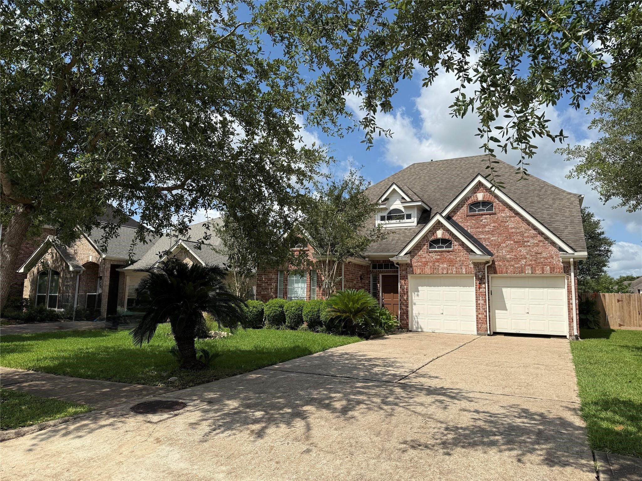 6714 Portuguese Bend Drive Missouri City, TX 77459 - Photo 1 of 13 a front view of a house with a yard and trees