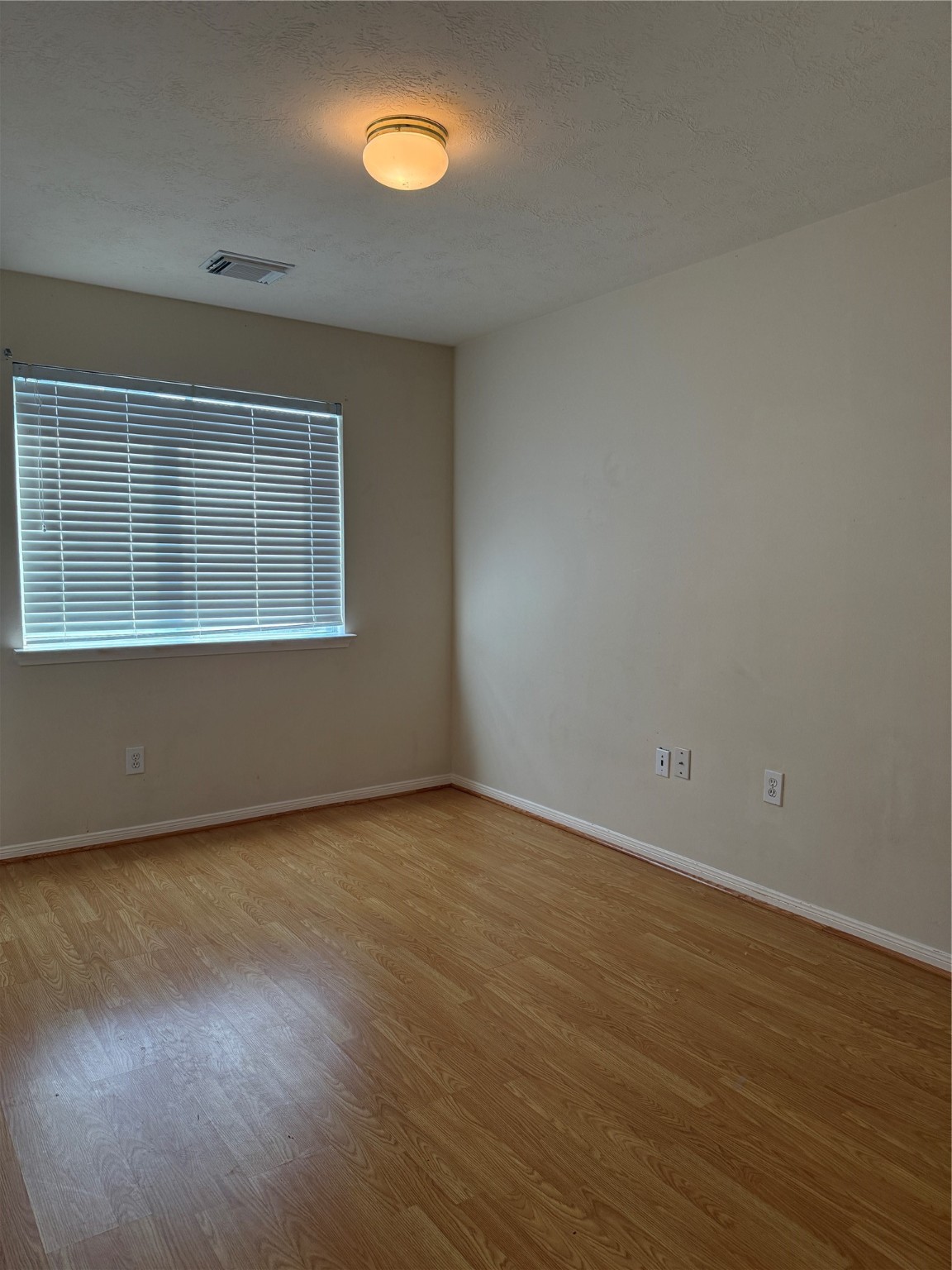 6714 Portuguese Bend Drive Missouri City, TX 77459 - Photo 11 of 13 an empty room with wooden floor and windows