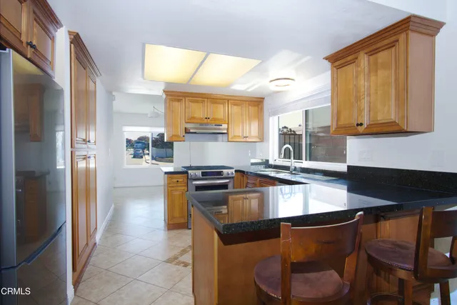 a kitchen with granite countertop a sink cabinets and stainless steel appliances