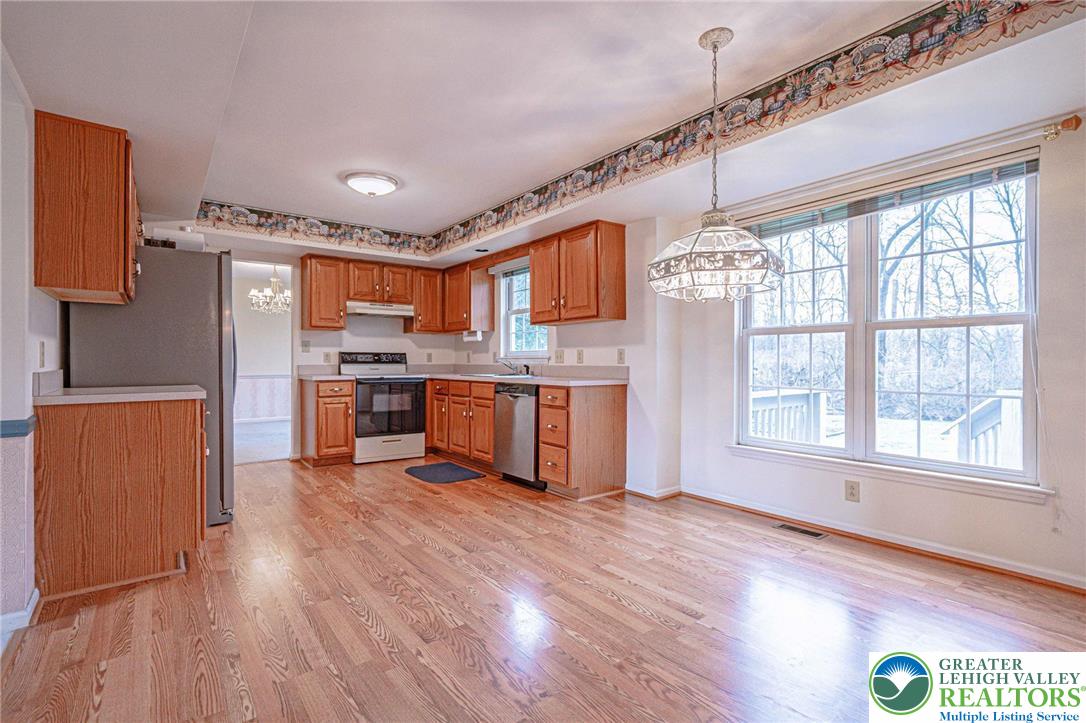40 Elk Court Reading, PA 19606 - Photo 19 of 46 a kitchen with stainless steel appliances granite countertop a refrigerator a sink dishwasher a stove and white countertops with wooden floor