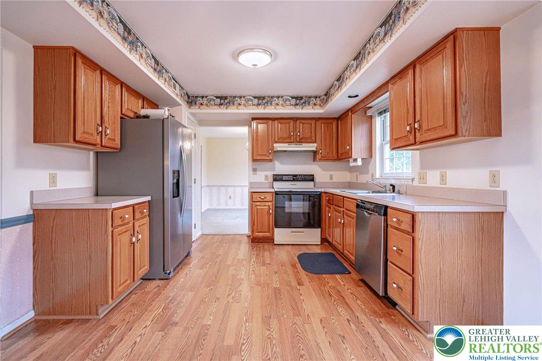 40 Elk Court Reading, PA 19606 - Photo 20 of 46 a large kitchen with stainless steel appliances wooden floors and wooden cabinets