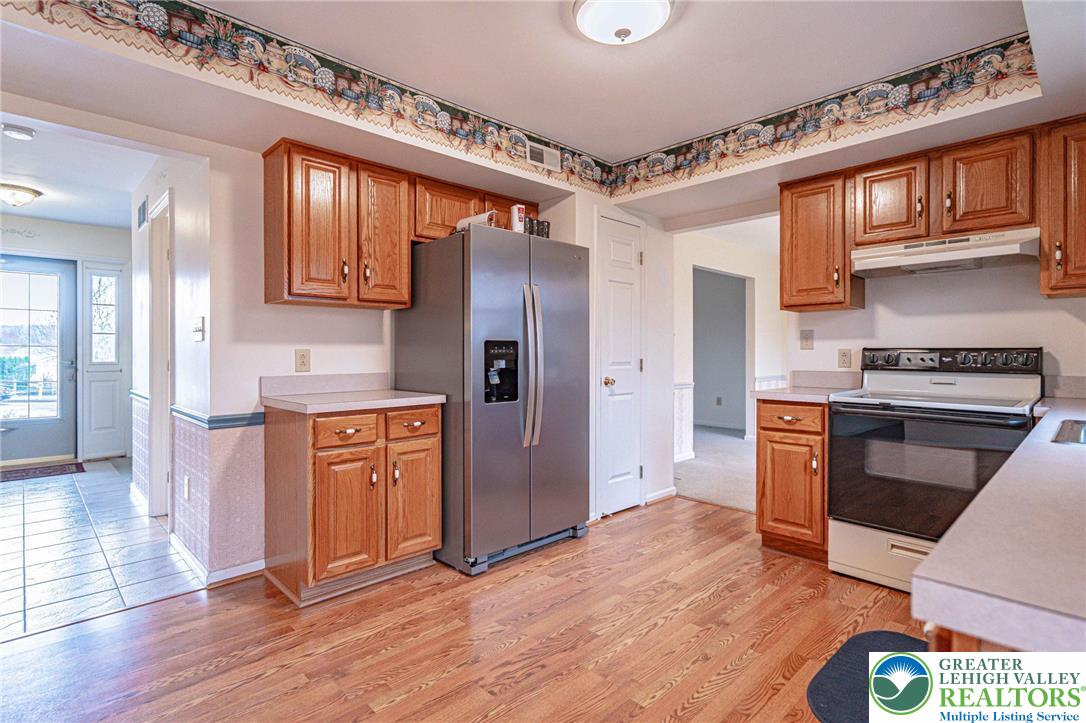 40 Elk Court Reading, PA 19606 - Photo 21 of 46 a kitchen with stainless steel appliances granite countertop a refrigerator a stove and a wooden floors