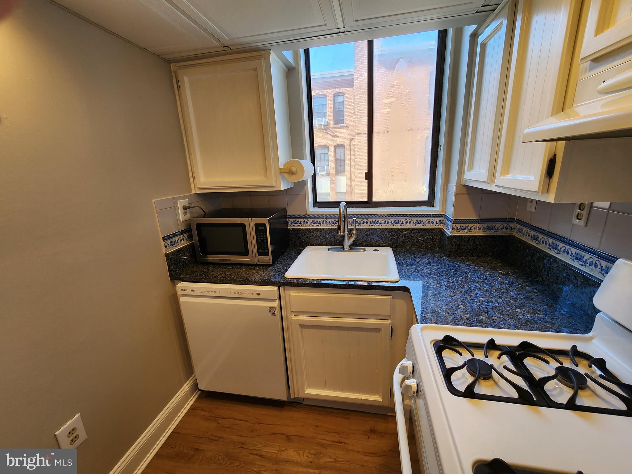 2610 Tunlaw Road Northwest, Unit 103 Washington, DC 20007 - Photo 11 of 36 a kitchen with a stove and a microwave