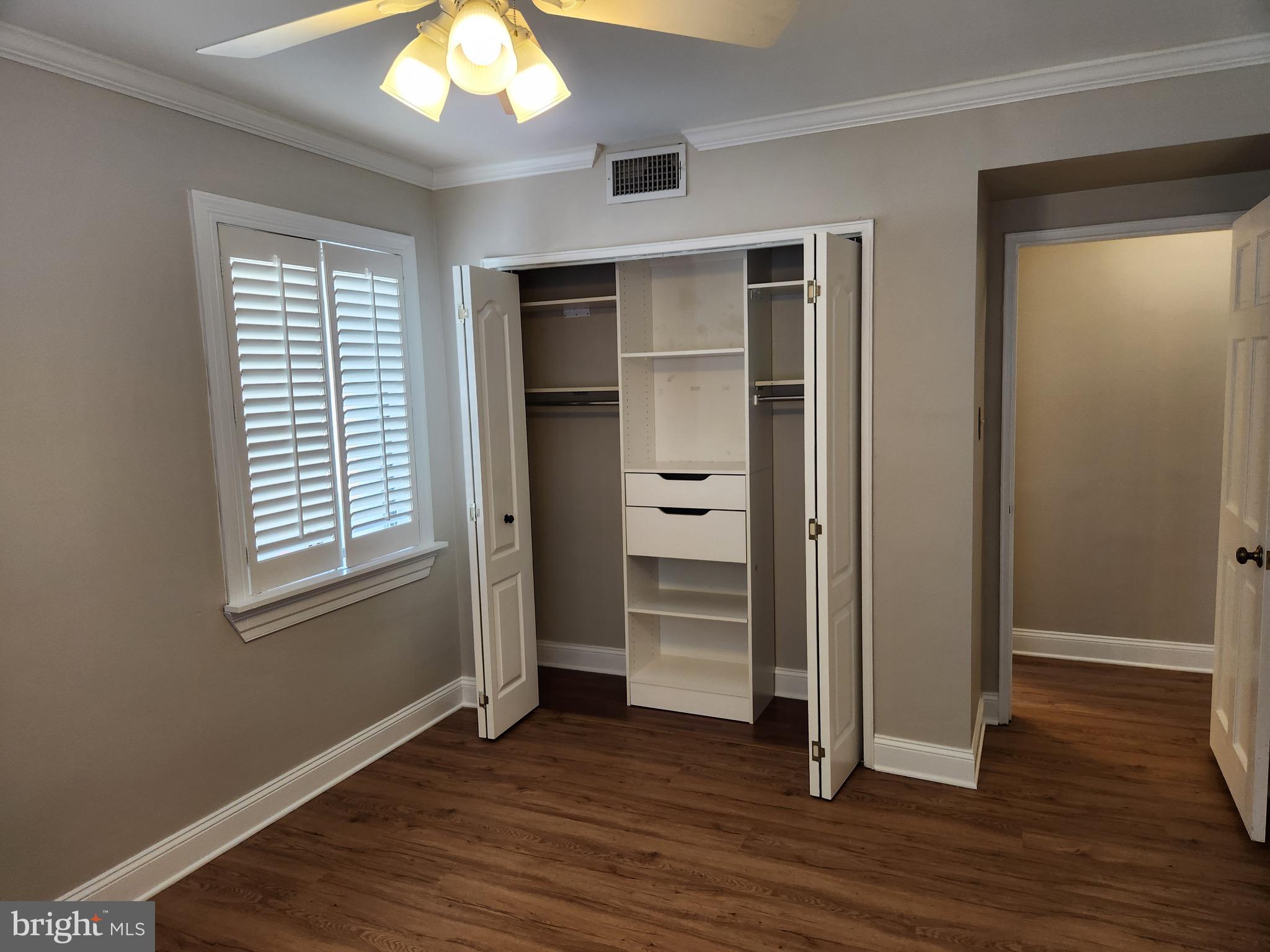 2610 Tunlaw Road Northwest, Unit 103 Washington, DC 20007 - Photo 14 of 36 an empty room with wooden floor closet and windows