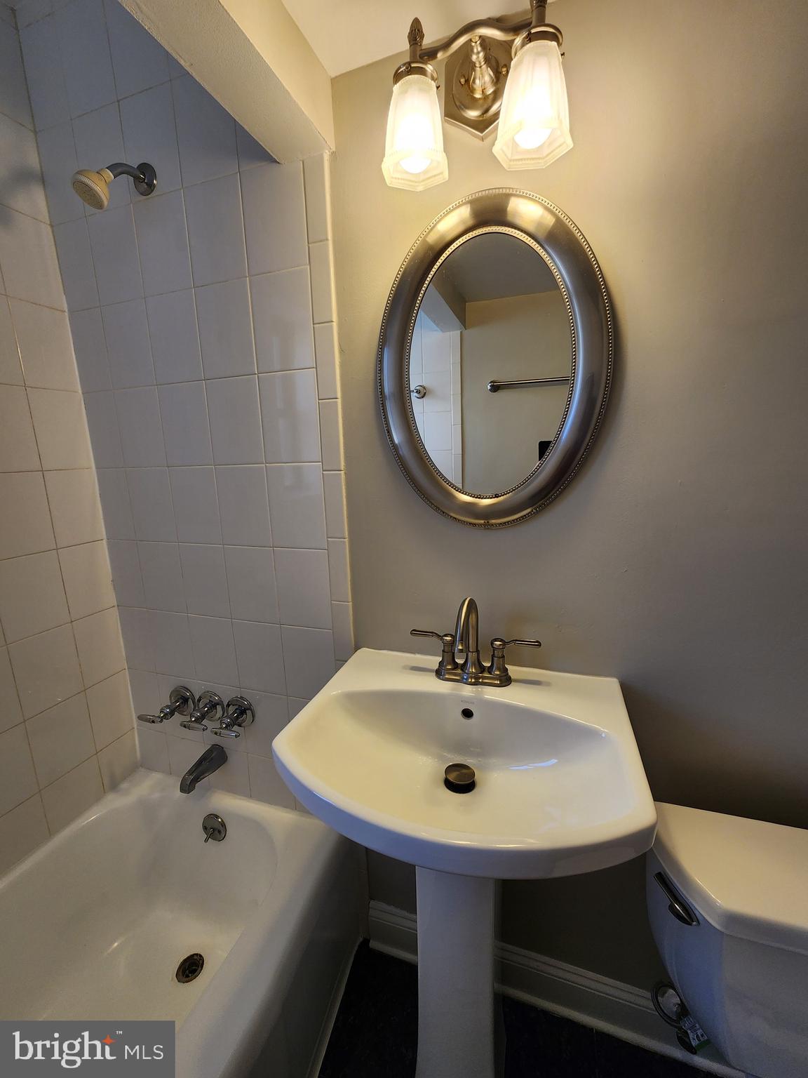 2610 Tunlaw Road Northwest, Unit 103 Washington, DC 20007 - Photo 30 of 36 a bathroom with a sink a toilet and a mirror