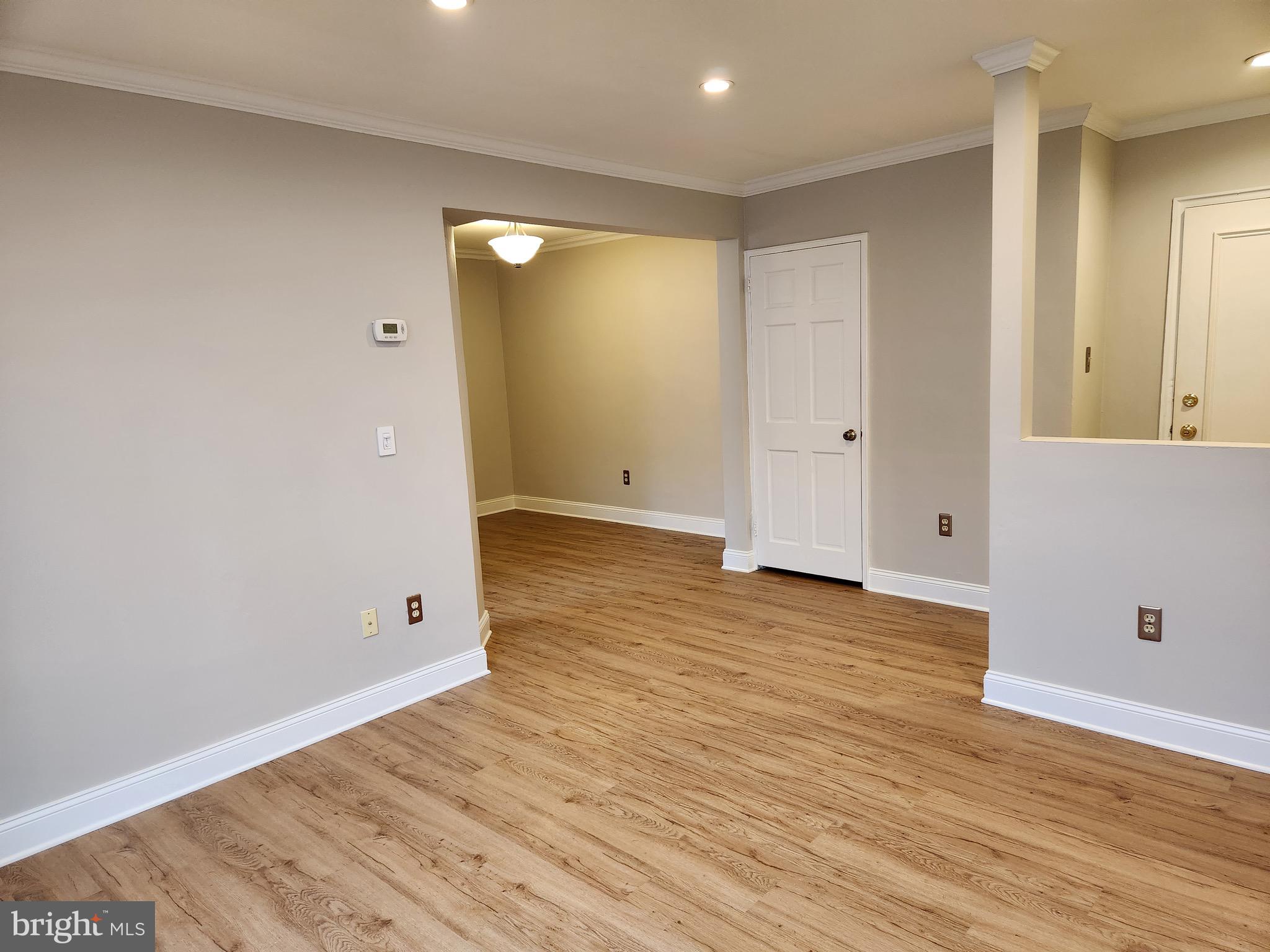 2610 Tunlaw Road Northwest, Unit 103 Washington, DC 20007 - Photo 7 of 36 a view of an empty room with wooden floor and a window