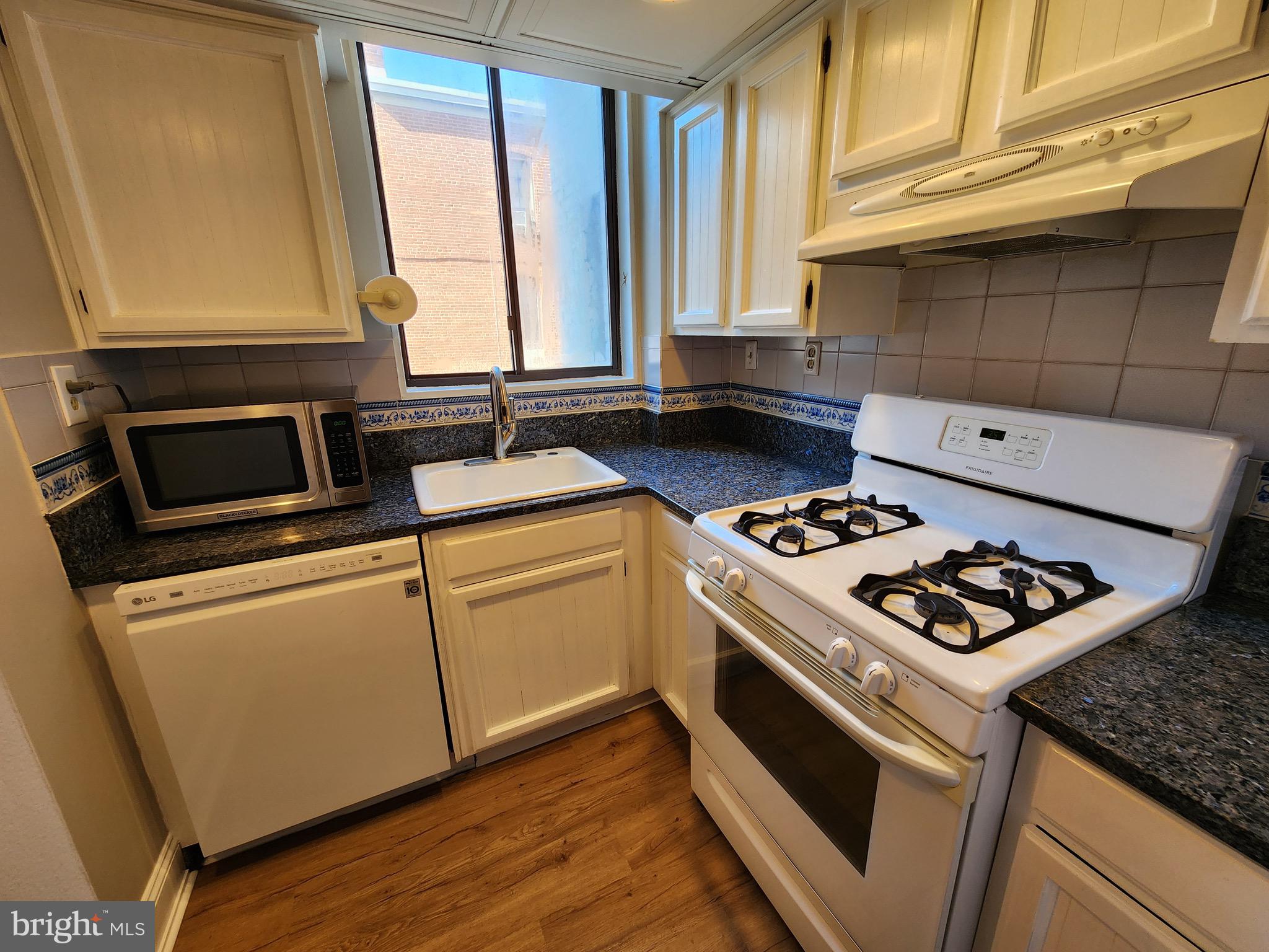 2610 Tunlaw Road Northwest, Unit 103 Washington, DC 20007 - Photo 8 of 36 a stove top oven sitting inside of a kitchen