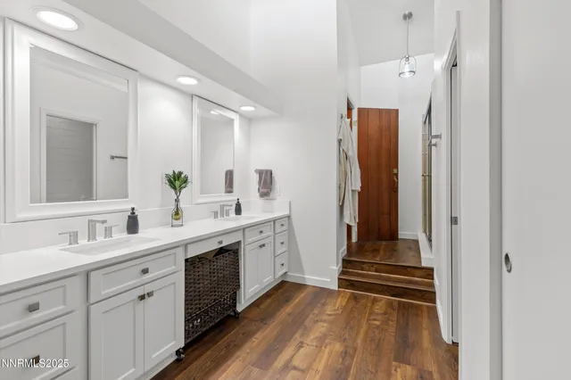 a bathroom with a double vanity sink mirror and next to a white cabinet