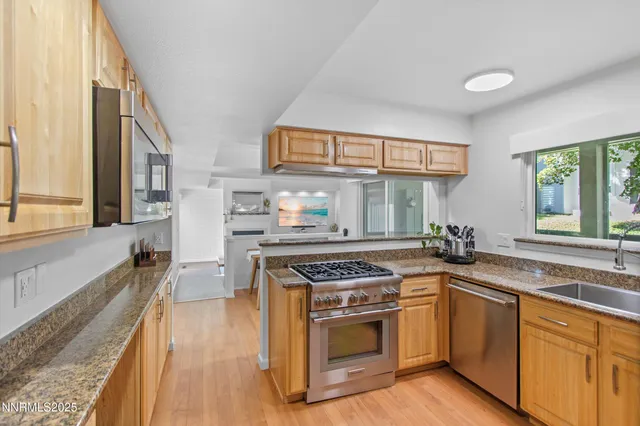 a kitchen with granite countertop a sink and a refrigerator