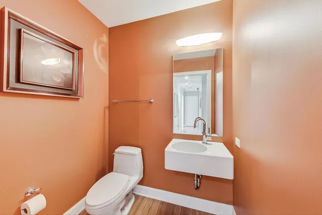 a bathroom with a toilet a sink and mirror