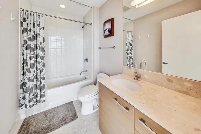 a bathroom with a granite countertop sink toilet and shower
