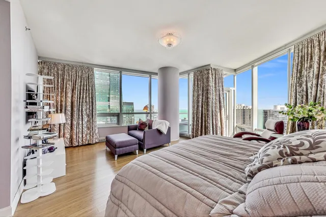 a bedroom with a bed and large windows