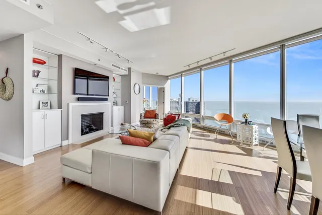 a living room with furniture fireplace and a large window