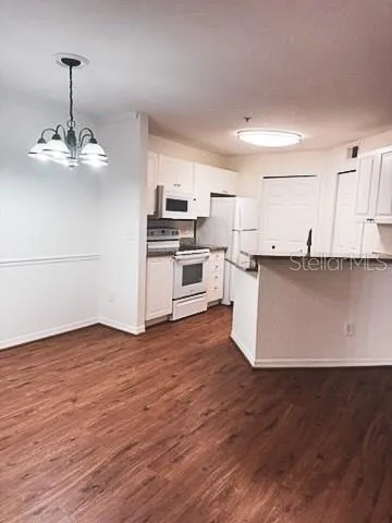 a view of a kitchen with stainless steel appliances wooden floor and a sink