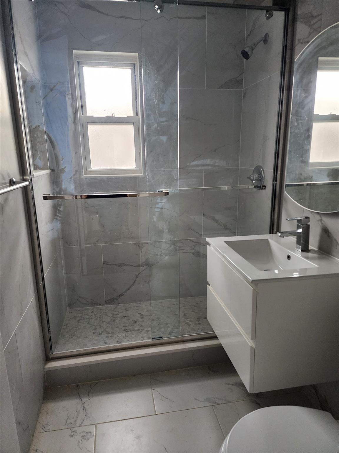 68-36 140th Street, Unit B Queens, NY 11367 - Photo 7 of 9 a bathroom with a sink a mirror and a shower
