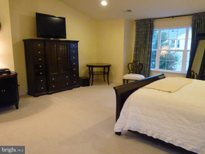 3721 Katie Place Triangle, VA 22172 - Photo 20 of 27 a bedroom with a bed and a flat tv screen on dresser