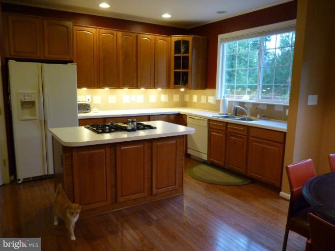 3721 Katie Place Triangle, VA 22172 - Photo 6 of 27 a kitchen with stainless steel appliances granite countertop wooden cabinets a stove a sink and a refrigerator