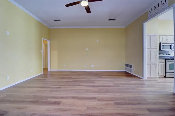 a view of empty room with wooden floor