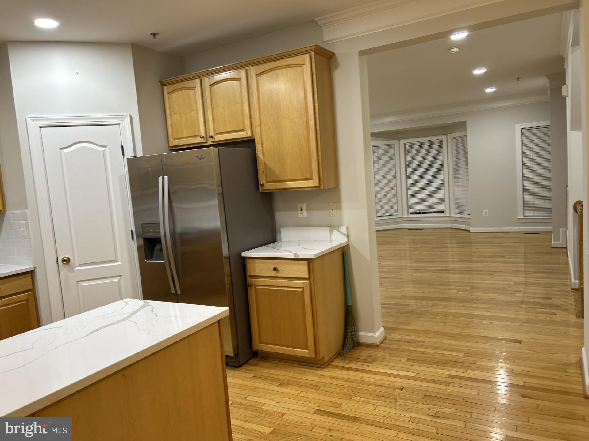 14030 Castle Ridge Way, Unit 27 Silver Spring, MD 20904 - Photo 6 of 19 a kitchen with stainless steel appliances a refrigerator sink and wooden cabinets