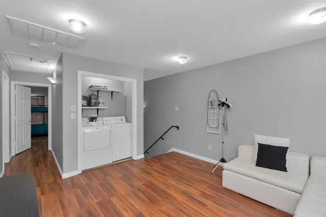 a view of a livingroom with wooden floor and a flat screen tv