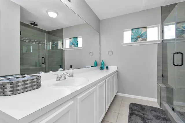 a bathroom with a double vanity sink a mirror and a shower