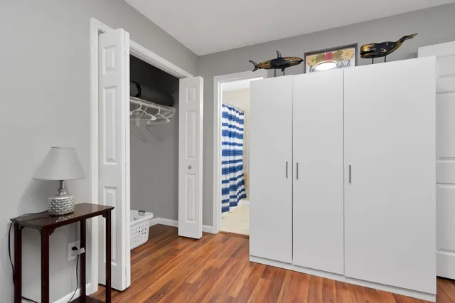 a view of a hallway with wooden floor and closet