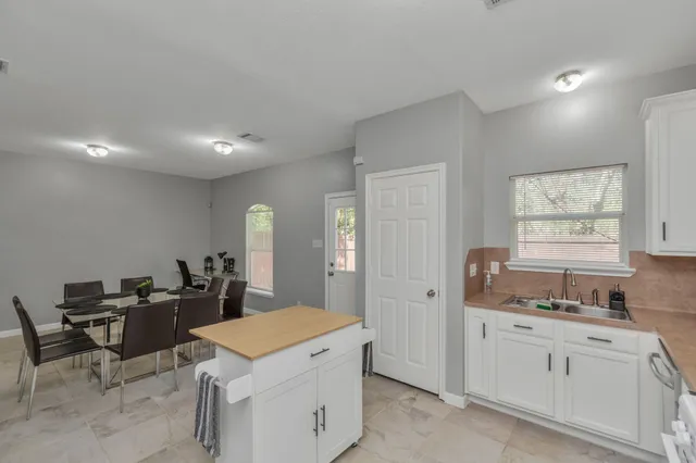 a kitchen that has a lot of cabinets a sink and a window in it