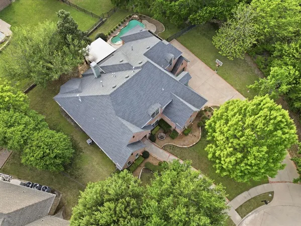 an aerial view of a house with a garden and lake view
