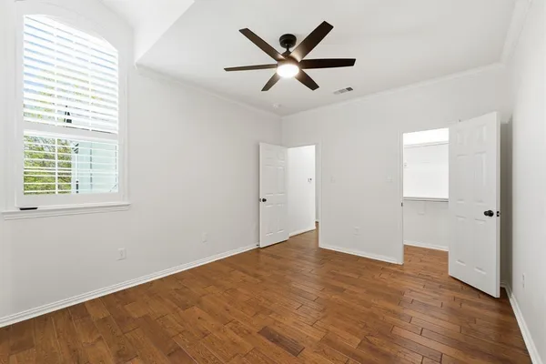 a view of a big room with wooden floor and windows