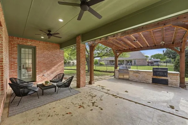 a view of a patio with table and chairs under an umbrella with a big yard