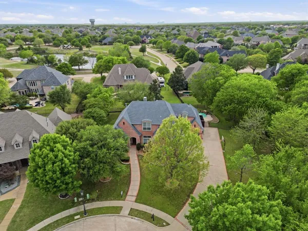 an aerial view of a house with garden space and trees all around
