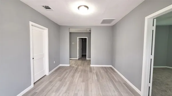 a view of a room with wooden floor and a hallway