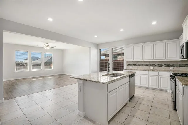 a kitchen with a sink window and cabinets