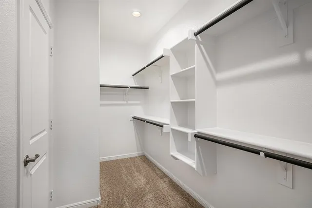 a view of walk in closet with empty racks