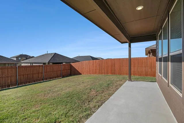 a view of backyard with wooden fence