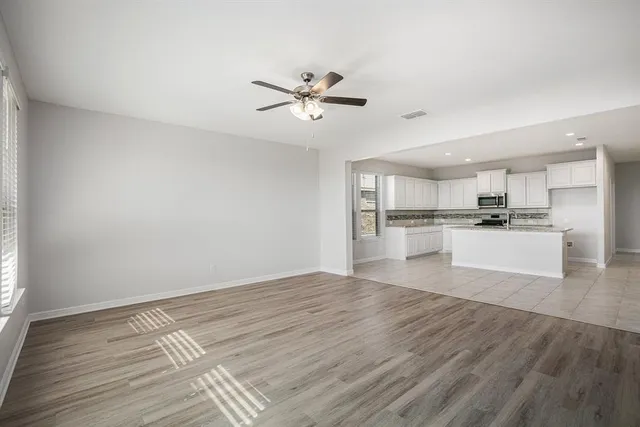 a view of kitchen with granite countertop cabinets and refrigerator