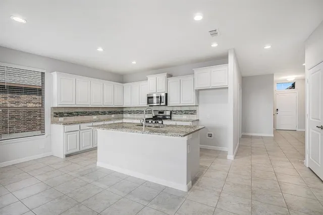 a kitchen with a sink window and cabinets