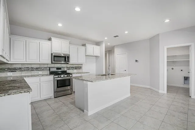 a large white kitchen with cabinets