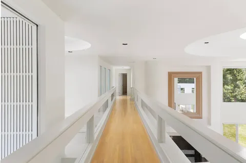 a view of a hallway with wooden floor and staircase